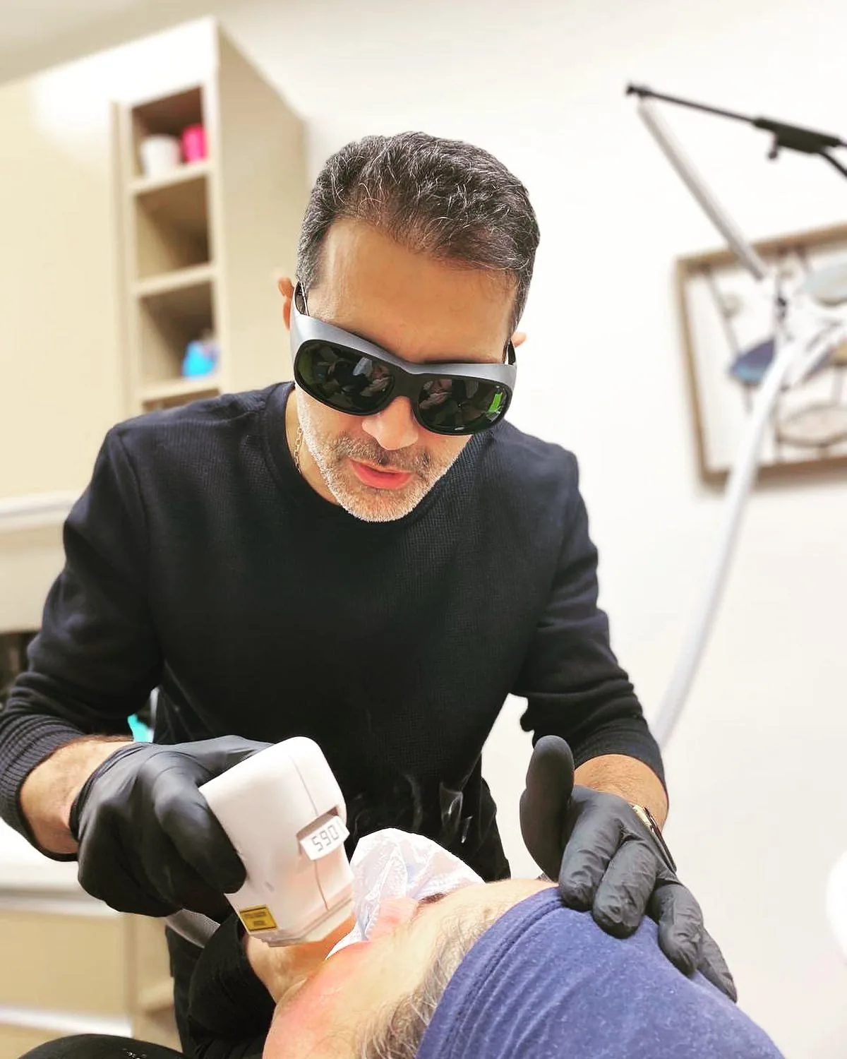 Dr. Şehriyar Nazari performing a procedure with protective glasses at the clinic